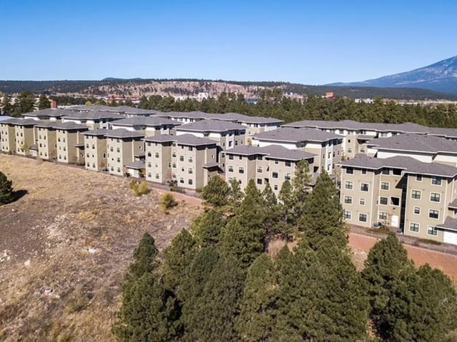 Apartment buildings with trees and hills exterior at Hilltop Townhomes in Flagstaff Student Accommodation