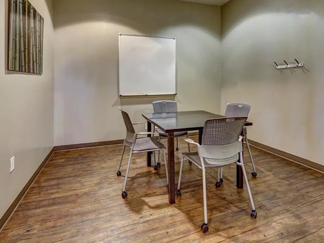 Table four chairs whiteboard wall art study area at Hilltop Townhomes in Flagstaff Student Accommodation