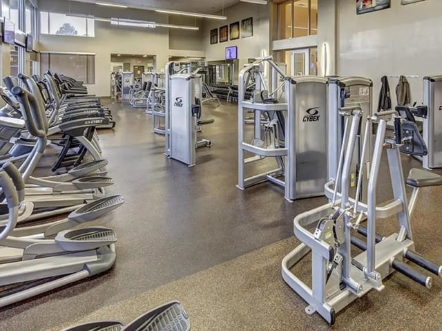 Gym equipment including ellipticals and weight machines Fitness center at Hilltop Townhomes in Flagstaff Student Accommodation