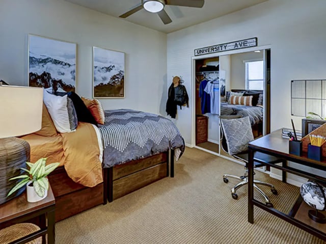 Bed desk closet and artwork student bedroom at Hilltop Townhomes in Flagstaff Student Accommodation
