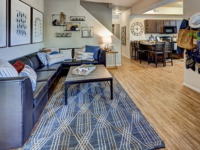 Sofa coffee table rug kitchen area living room at Hilltop Townhomes in Flagstaff Student Accommodation