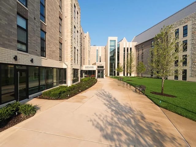 Modern building entrance with concrete pathway and green lawn exterior at Honors Academic Village in Toledo Student Accommodation