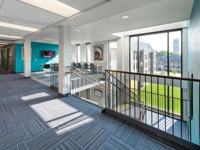 Hallway with stairs and view of campus building at Honors Academic Village in Toledo Student Accommodation
