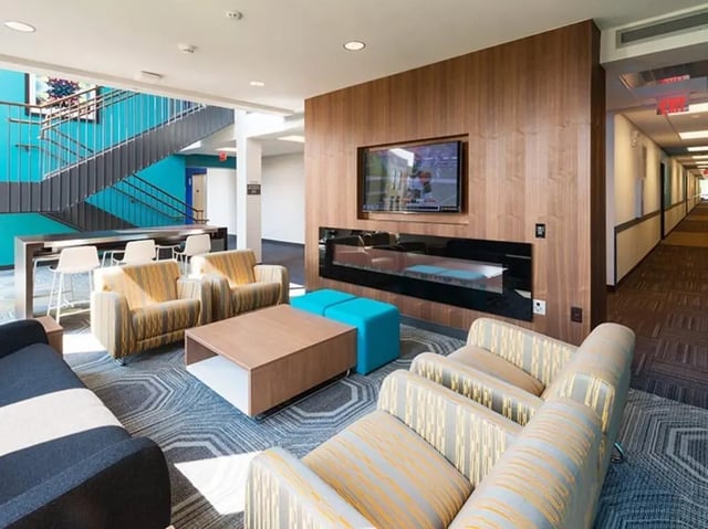 Modern lounge with seating fireplace and TV living room at Honors Academic Village in Toledo Student Accommodation
