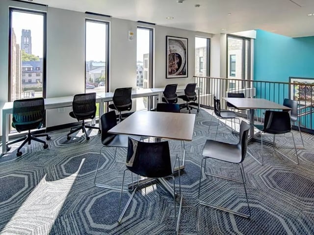 Desks chairs tables and windows common area study space at Honors Academic Village in Toledo Student Accommodation