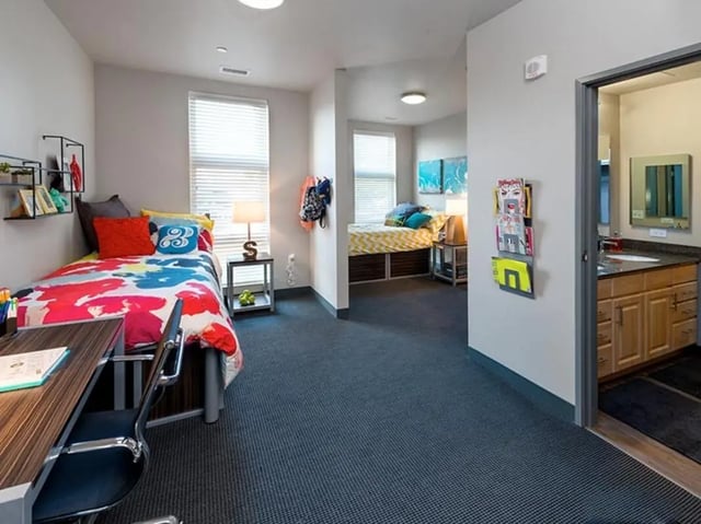 Two beds desk chair shelves and bathroom bedroom at Honors Academic Village in Toledo Student Accommodation