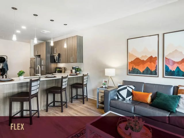 Kitchen island with bar stools and living area Living room at Stadium Centre - The Axis in Tallahassee Student Accommodation