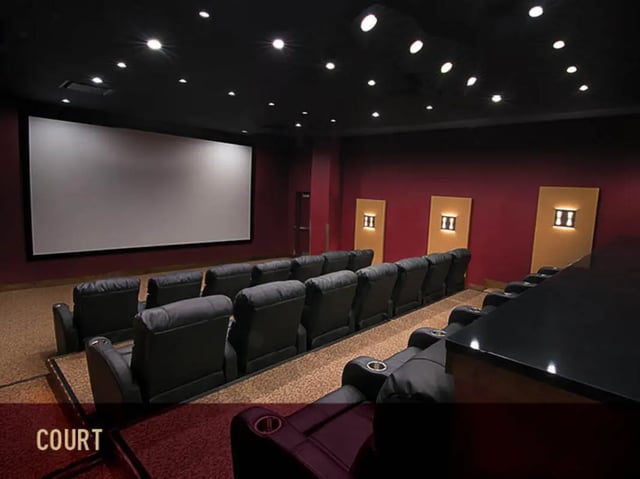 Dark theater room with reclining chairs and screen theater room at Stadium Centre - The Block in Tallahassee Student Accommodation