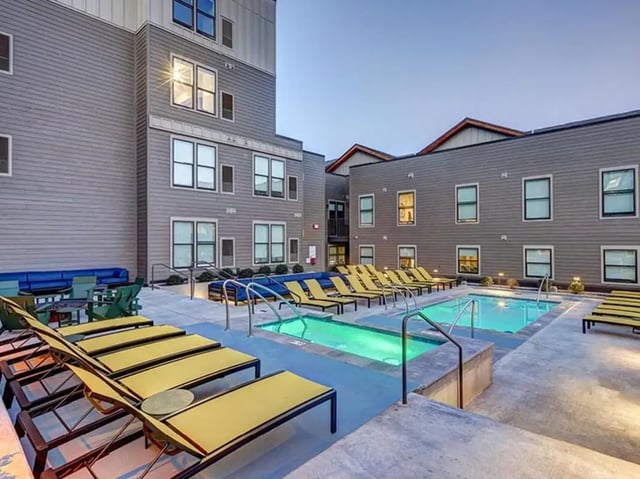 Pool with lounge chairs and seating area exterior at The Jack in Flagstaff Student Accommodation