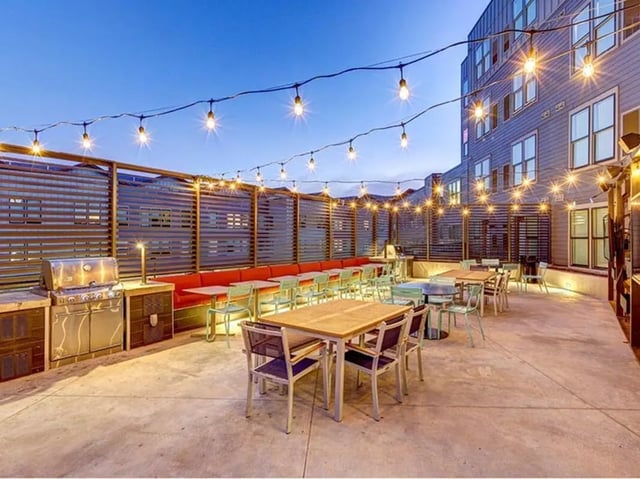 Grill tables chairs string lights outdoor common area at The Jack in Flagstaff Student Accommodation