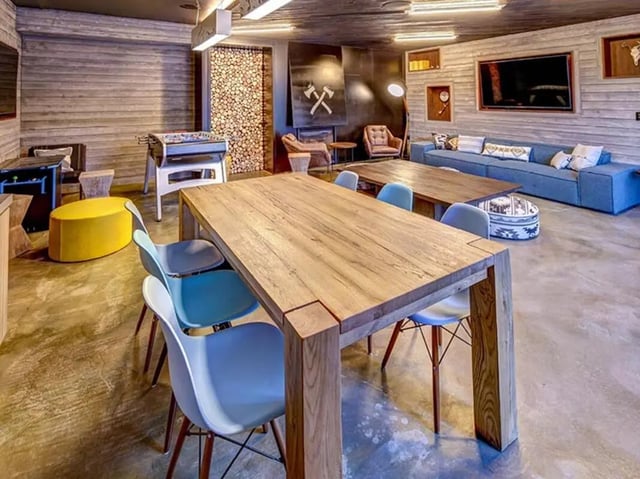 Wooden tables chairs foosball sofa lounge area at The Jack in Flagstaff Student Accommodation