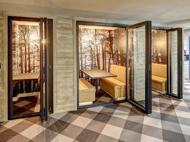 Booth seating with tables and forest wallpaper common area at The Jack in Flagstaff Student Accommodation