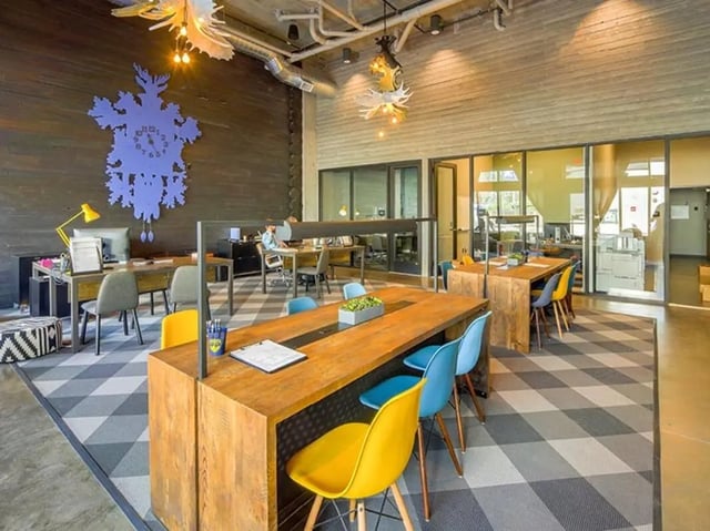 Wooden tables colorful chairs large clock study area at The Jack in Flagstaff Student Accommodation