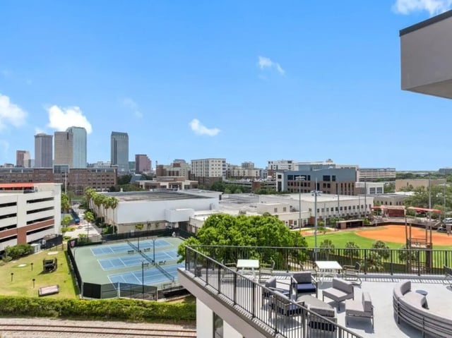 Rooftop patio furniture tennis courts and cityscape exterior at Apella on Newport in Tampa Student Accommodation