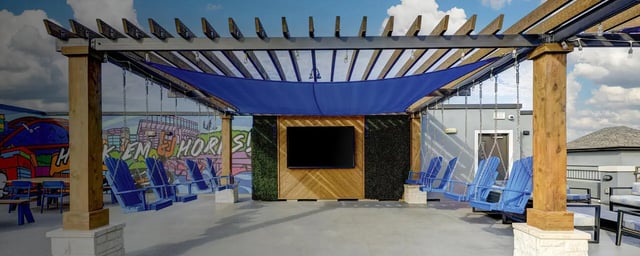 Blue Adirondack swings and seating under pergola outdoor living area at The Block on 28th in Austin Student Accommodation