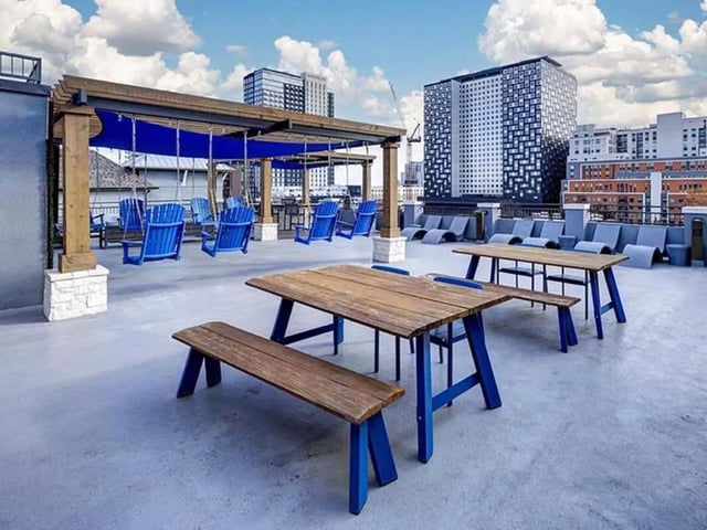 Picnic tables and blue swings rooftop amenity area at The Block on 28th in Austin Student Accommodation