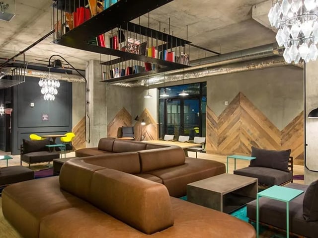 Brown sectional couch coffee tables chandeliers living room at The James in Madison Student Accommodation