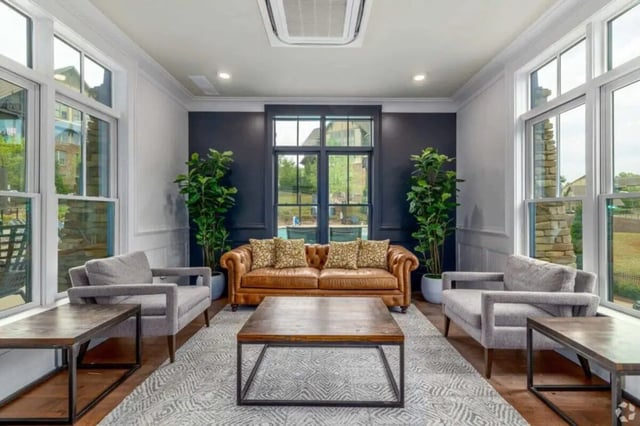 Brown leather sofa with grey chairs living room at Arcadia Student Living in Charlotte Student Accommodation