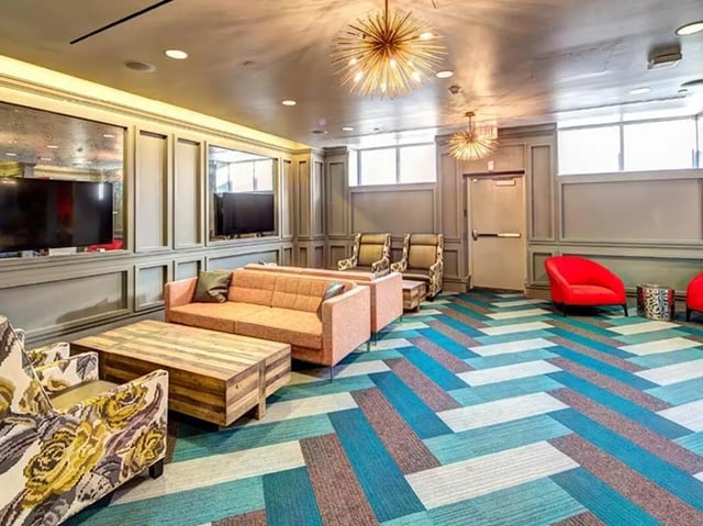 Sofas coffee table chairs TVs living room at University Crossings in Philadelphia Student Accommodation