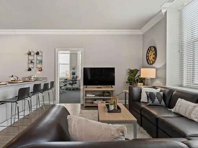 Kitchen bar stools TV coffee table couch living room at University Crossings in Philadelphia Student Accommodation