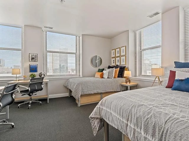 Two beds desks and chairs bedroom at University Crossings in Philadelphia Student Accommodation