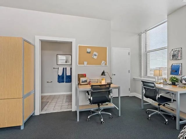 Two desks chairs corkboard towels study area at University Crossings in Philadelphia Student Accommodation
