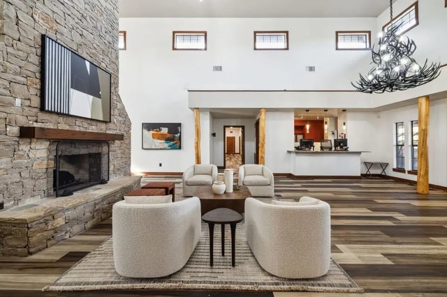 Stone fireplace abstract art plush chairs living room at Montara Park in Norman Student Accommodation