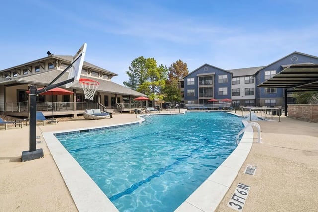 Basketball hoop pool lounge chairs umbrellas swimming pool area at Montara Park in Norman Student Accommodation