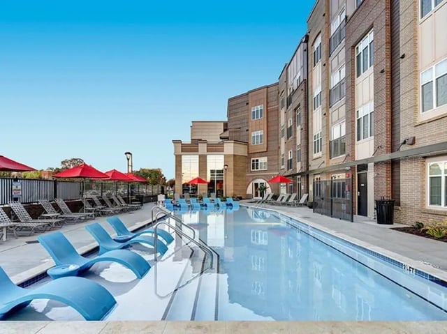 Blue lounge chairs and swimming pool exterior at University Crossings Charlotte in Charlotte Student Accommodation