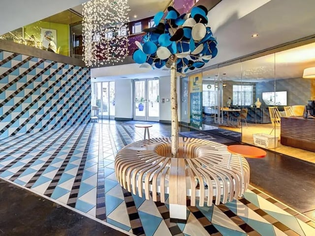 Circular bench around tree decorative wall flooring lobby at University Crossings Charlotte in Charlotte Student Accommodation