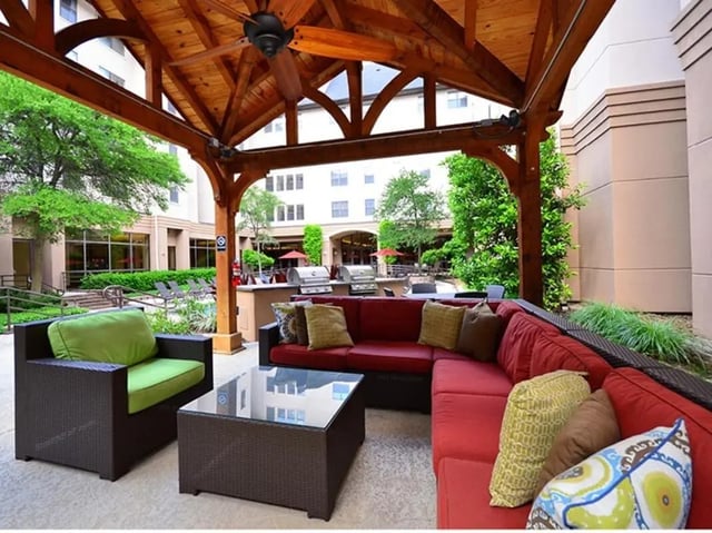 Outdoor seating and grills under covered patio living area. at The Callaway House in College Station Student Accommodation