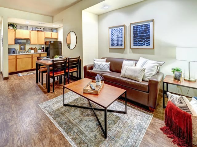 Leather sofa dining table kitchen and rug living area at The Callaway House in College Station Student Accommodation