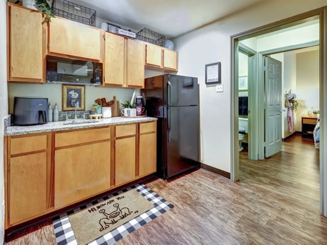 Kitchen with wood cabinets microwave and refrigerator kitchen at The Callaway House in College Station Student Accommodation