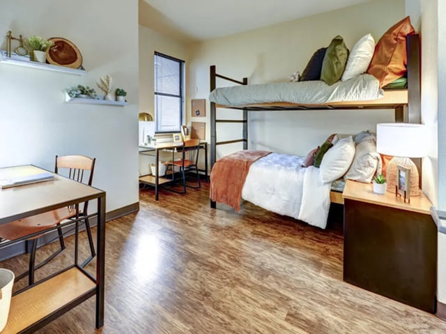 Bunk beds desk and chair with shelving Student room at The Callaway House in College Station Student Accommodation