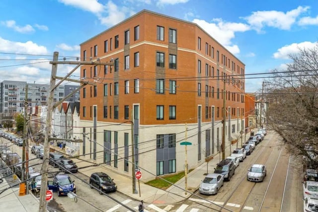 Brick building with cars parked along street exterior at Paloma University City in Philadelphia Student Accommodation