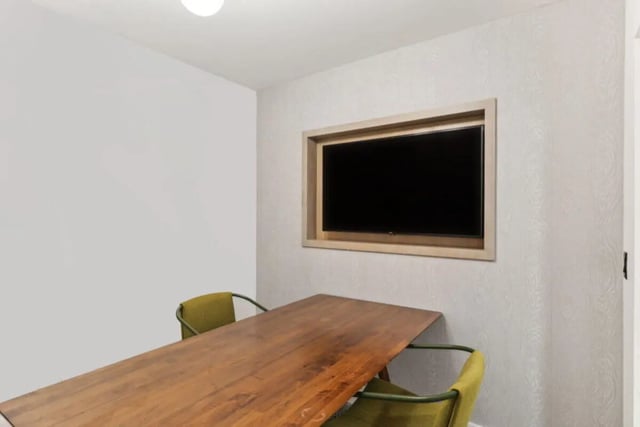 Wooden table chairs and wall mounted television common area at Paloma University City in Philadelphia Student Accommodation