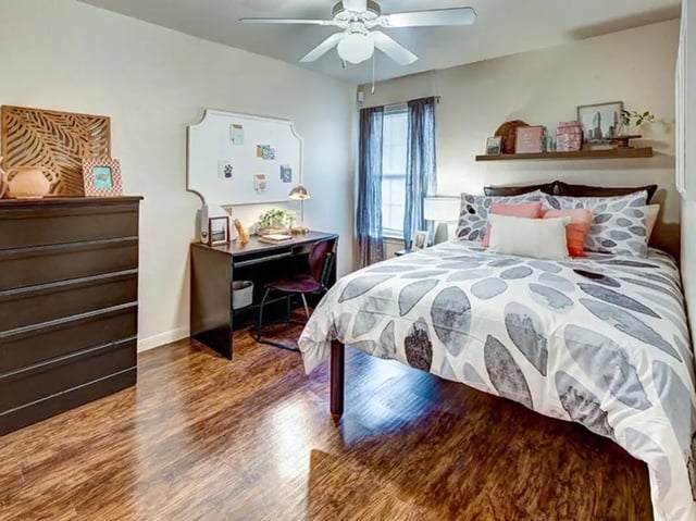 Dark dresser desk bed and whiteboard Bedroom at University Trails in Lubbock Student Accommodation