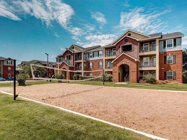 Volleyball court next to apartment buildings exterior at University Trails in Lubbock Student Accommodation