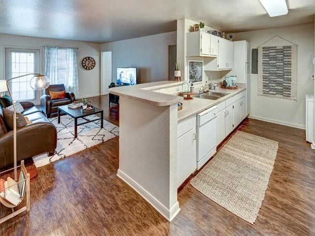 Leather couches coffee table kitchen island living room at University Trails in Lubbock Student Accommodation