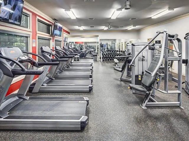 Treadmills weight machines televisions gym area fitness room at University Trails in Lubbock Student Accommodation