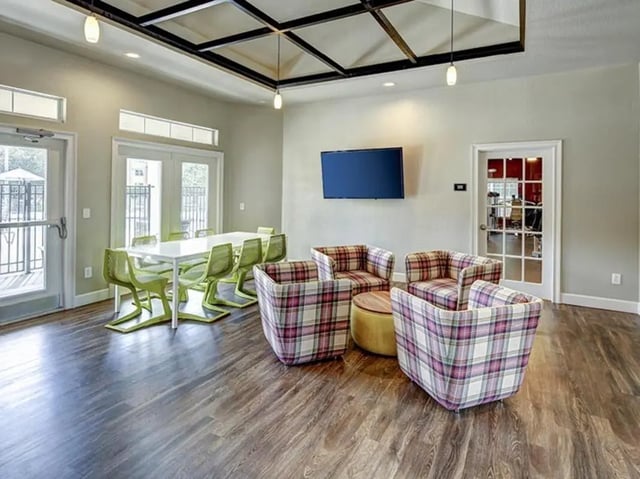 Plaid chairs coffee table television dining table living area at The Village At Science Drive in Orlando Student Accommodation