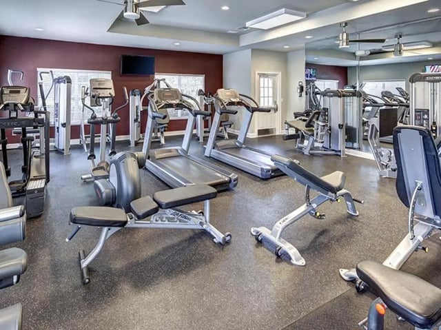 Gym with treadmills and weight benches gym area at The Village At Science Drive in Orlando Student Accommodation
