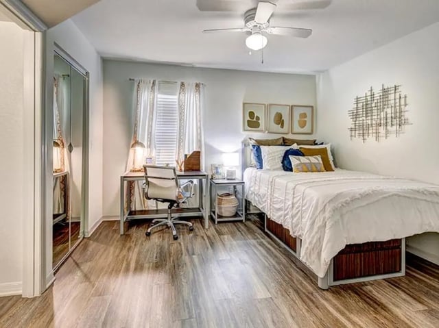 Bed desk and closet with mirrored doors bedroom at The Village At Science Drive in Orlando Student Accommodation