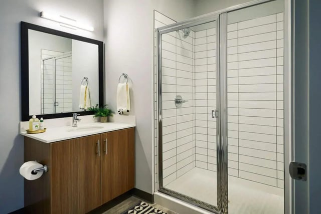 Vanity mirror sink shower with white tiles bathroom at Seven07 in Champaign Student Accommodation