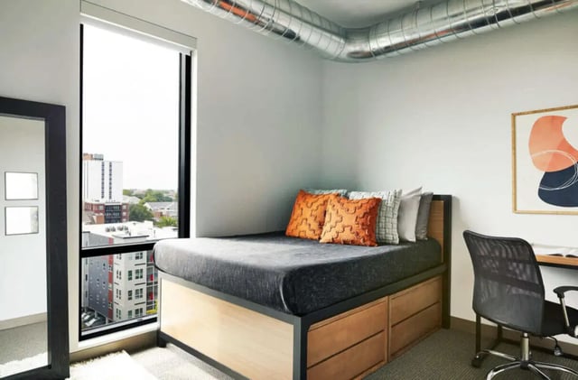 Bed with drawers pillows desk and chair bedroom at Seven07 in Champaign Student Accommodation