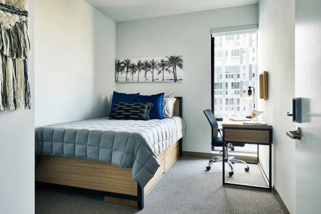 Bed desk chair artwork and wall hanging bedroom at Seven07 in Champaign Student Accommodation