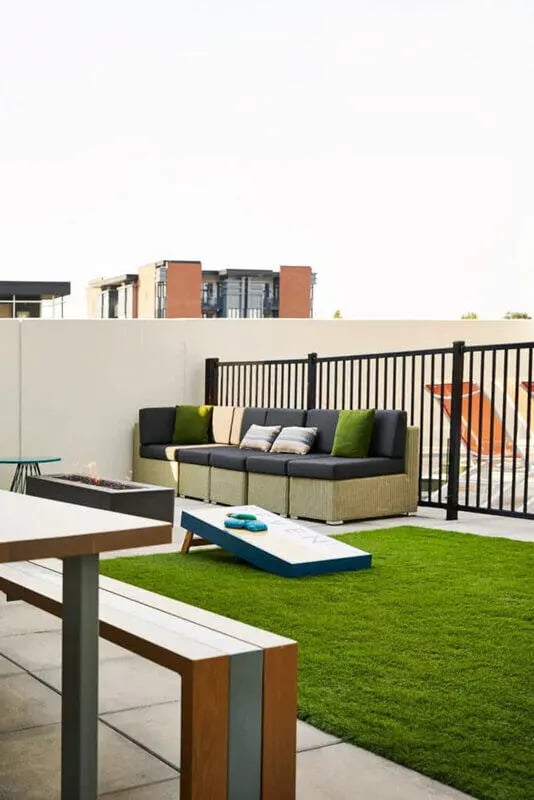 Sofa fire pit cornhole on grass playing area at Seven07 in Champaign Student Accommodation