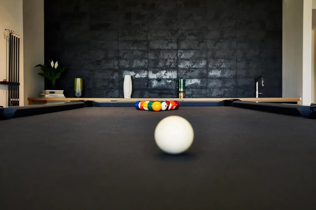 Pool table with cue rack and balls playing area at Seven07 in Champaign Student Accommodation