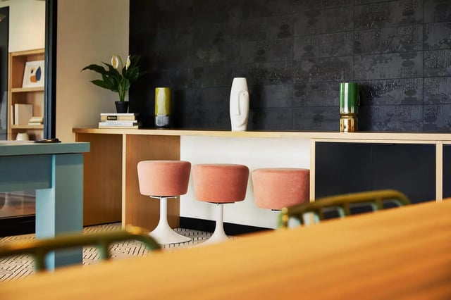 Pink stools and desk area living room at Seven07 in Champaign Student Accommodation