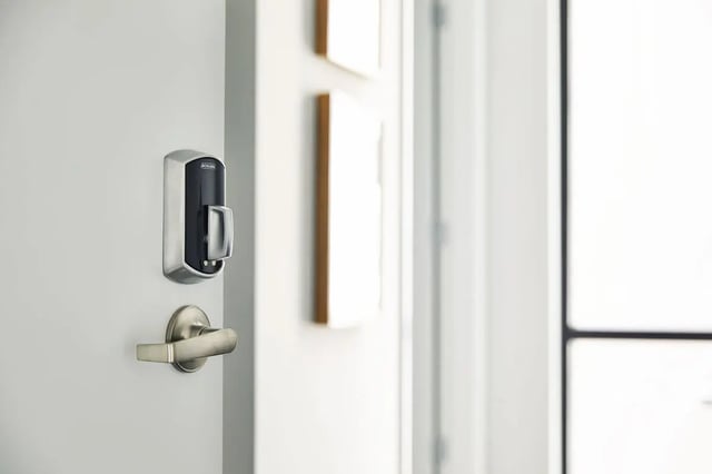 Smart door lock and handle on white door exterior at Seven07 in Champaign Student Accommodation
